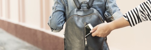 Pickpocket Dieb stiehlt ein Smartphone aus einem Rucksack