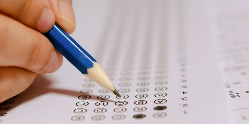 Bleistift und Hand füllt Prüfungsbogen aus