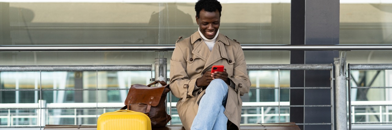 Reisender am Flughafen nutzt sein Smartphone