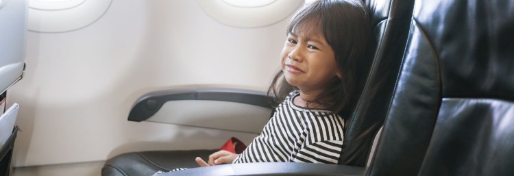 Kleines Mädchen sitzt im Flugzeug und hat Angst