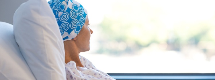 Krebspatientin blickt sorgenvoll aus dem Fenster