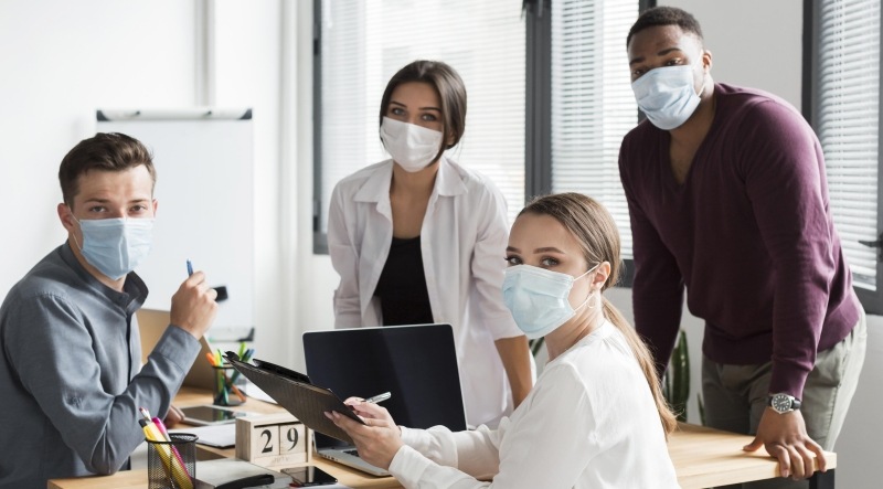 Team am Arbeitsplatz während der Corona Pandemie