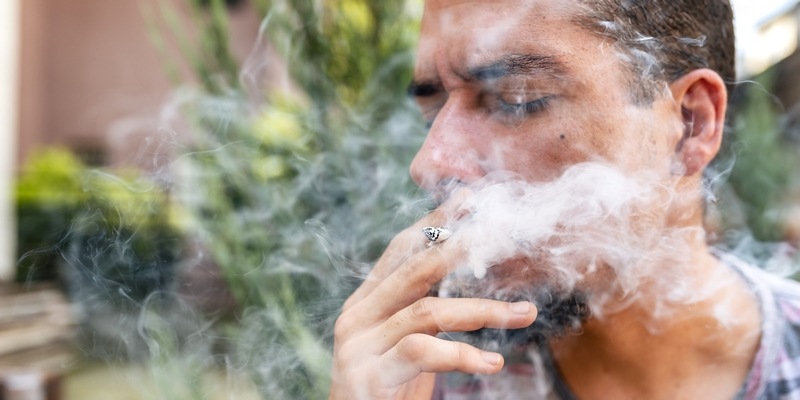 junger Mann raucht einen Marijuana Joint