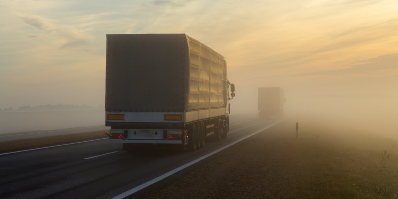 Lastwagen fahren auf einer nebeligen Straße