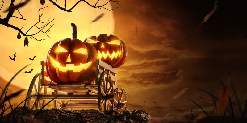 Halloween Kürbisse aus einem Leiterwagen vor einem Vollmond