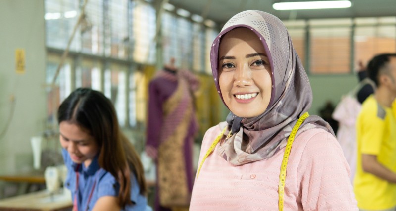 Fröhliche Muslima mit Hijab bei der Ausbildung