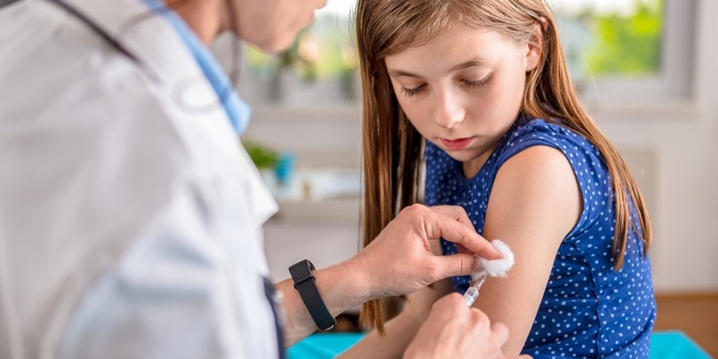 Ärztin gibt einem kleinen Mädchen eine Schutzimpfung