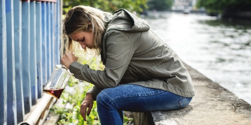 deprimierte Junge Frau mit Alkohol