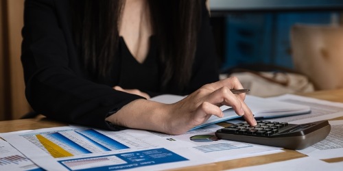 Unternehmerin tippt auf Taschenrechner