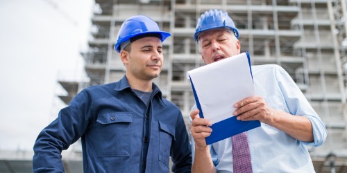 Architekt und Bauleiter lesen ein Protokoll