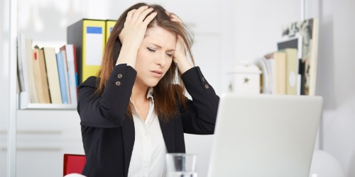 Frau rauft sich die Haare vor Computer