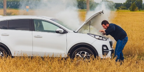 Mann schaut verzweifelt in brennendes Fahrzeug