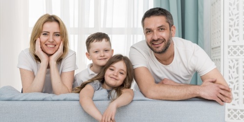 Familie kniet auf Sofa