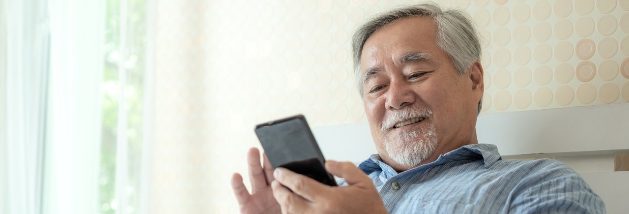 älterer Herr mit Smartphone in der Hand