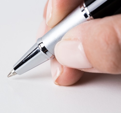 schreibende Hand mit Kugelschreiber