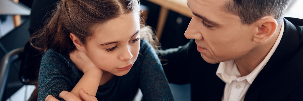 Vater legt den Arm um seine kleine Tochter