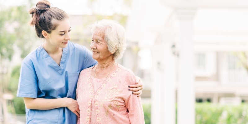Krankenschwester umarmt ältere Frau