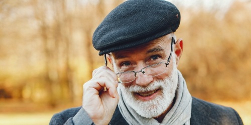 älterer Mann blickt freundlich über seine Brille