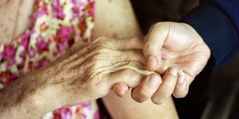 junge Hand hält die Hand einer älteren Person