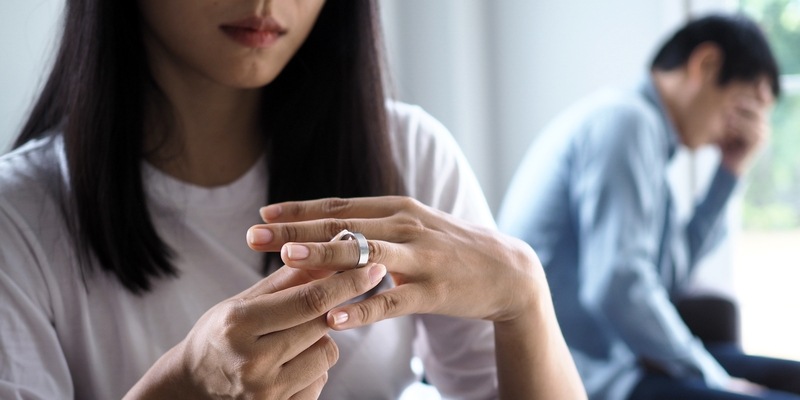 Frau zieht Ring vom Finger bei Scheidung