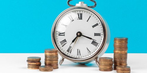 Wecker Uhr mit Münzen auf Tisch Ablauf Steuerfrist