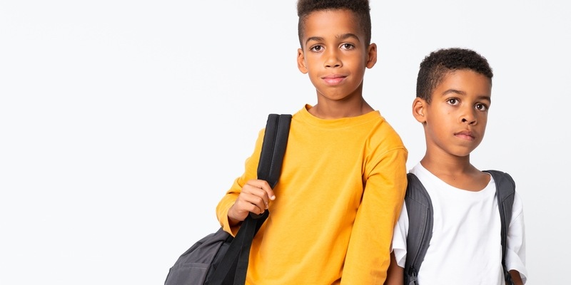 zwei Schulkinder tragen ihre Schulranzen
