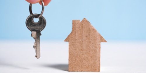 ein Schlüssel und Haus aus Pappe