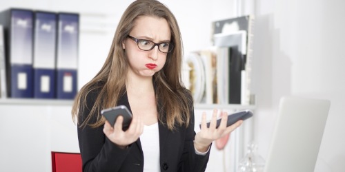 zornige junge Frau mit defektem Smartphone