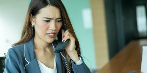 Frau ärgert sich am Telefon wegen Mietangelegenheit