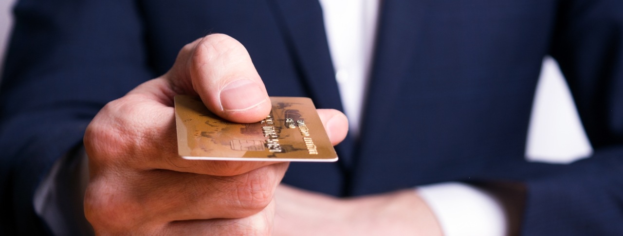 Hand übergibt eine Kreditkarte zur Bezahlung Kauf