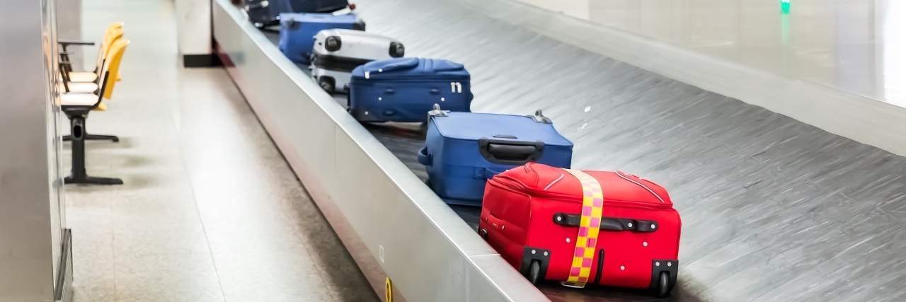 bunte Koffer auf einem Gepäckband am Flughafen
