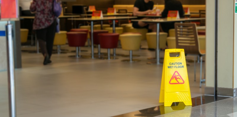 Warnschild Vorsicht rutschig im Supermarkt