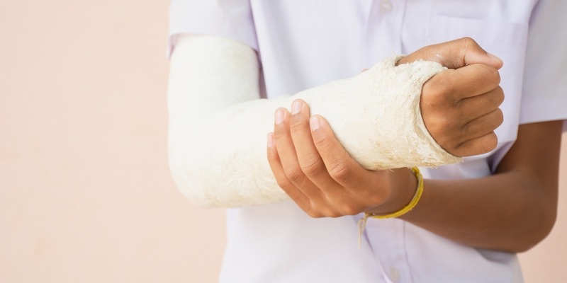 schmerzender gebrochener Arm in weißem Gipsverband