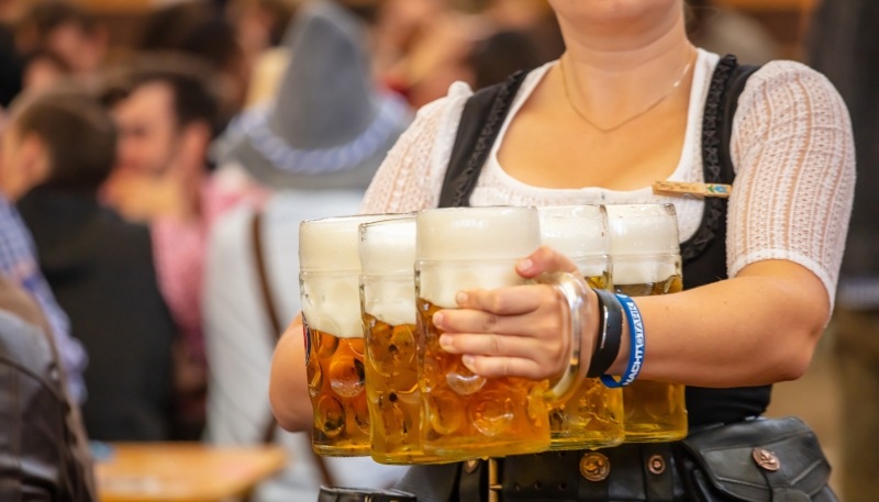 Bedienung trägt Maßkrüge auf dem Oktoberfest