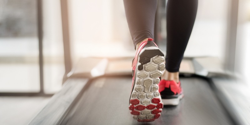 Frau mit Turnschuhen im Fitnessstudio auf dem Laufband